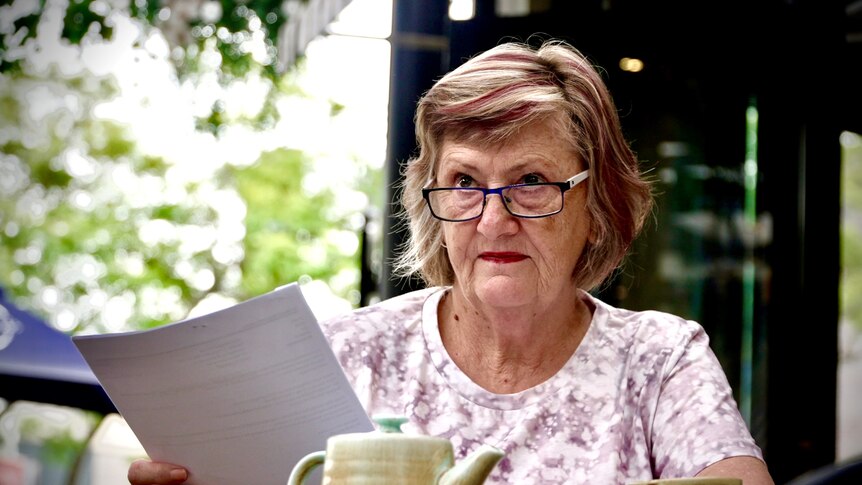 六十多岁的女人在咖啡馆看文件 